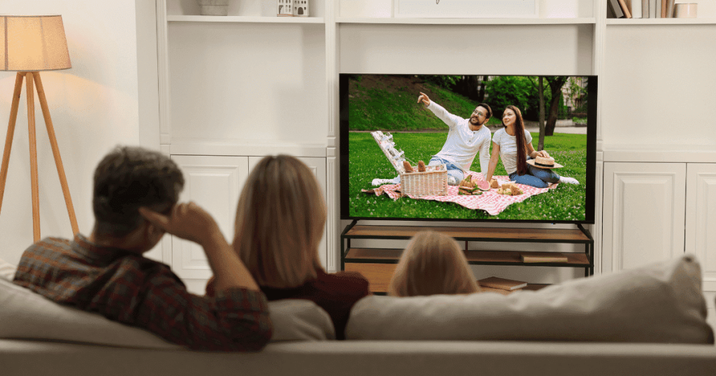 ソファに座ってテレビを見る家族