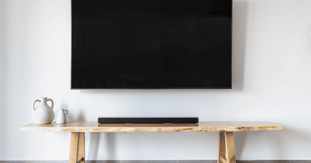 壁掛けテレビと木製の台に置かれたサウンドバー