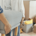 段ボールが置かれた部屋で椅子を運ぶ人