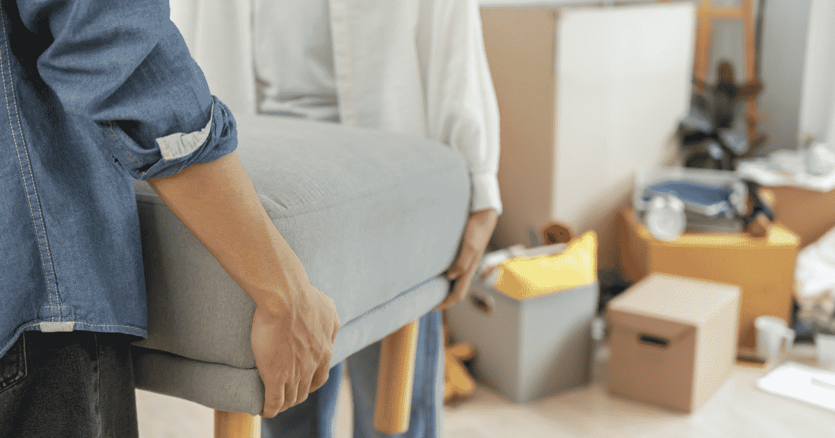 段ボールが置かれた部屋で椅子を運ぶ人