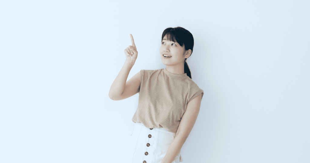 人差し指で上を指さす女性
