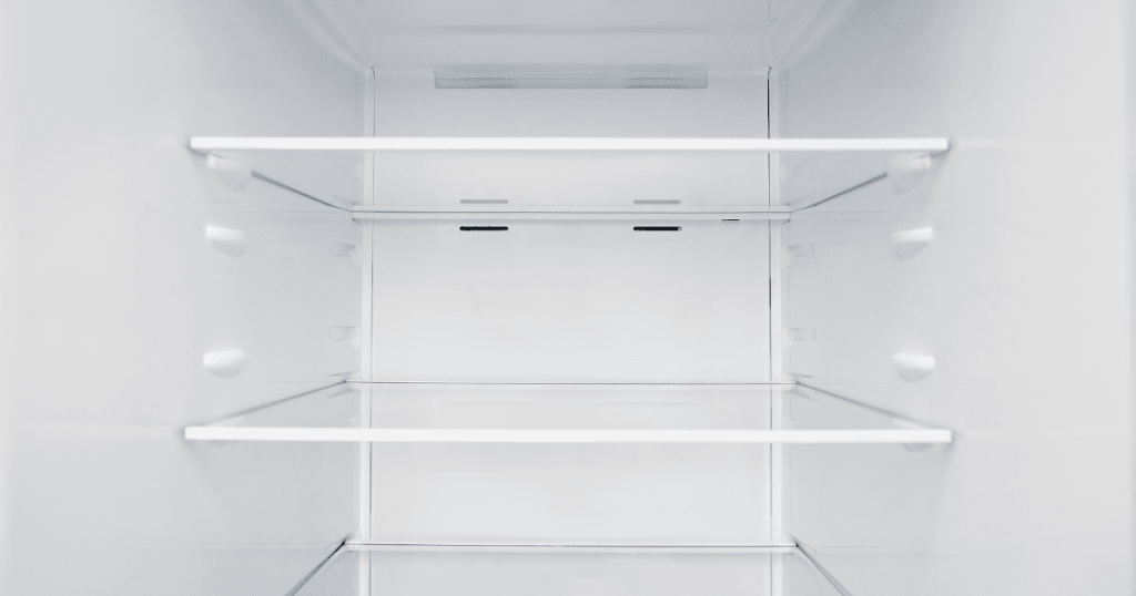 ガラス棚が並ぶ、食品の入っていない冷蔵庫の庫内