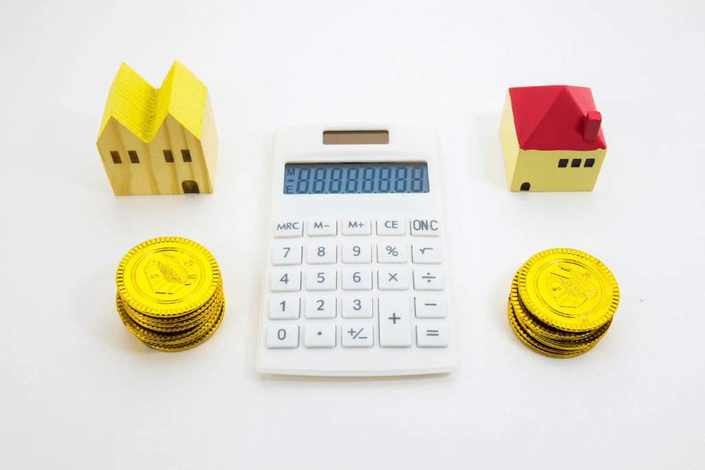 家の模型・電卓・コインが並ぶ様子