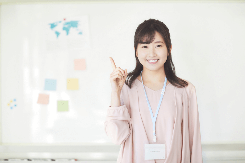 ホワイトボードの前で説明する女性スタッフ