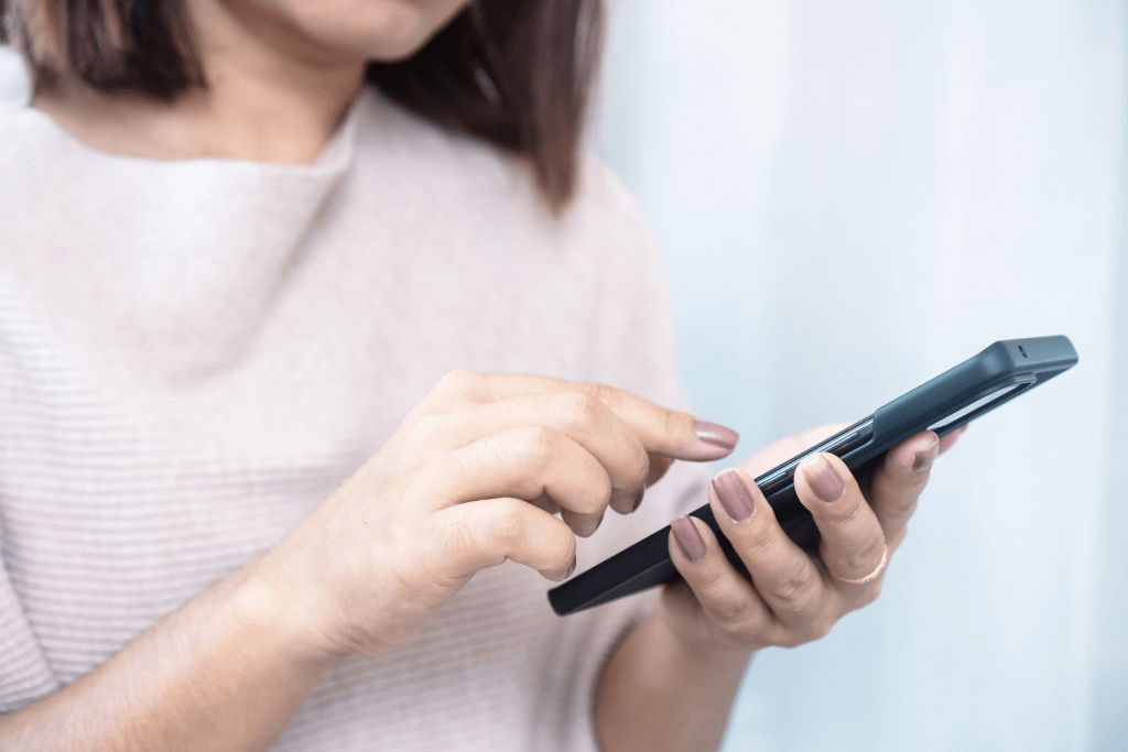 スマートフォンを操作している女性の手元のアップ