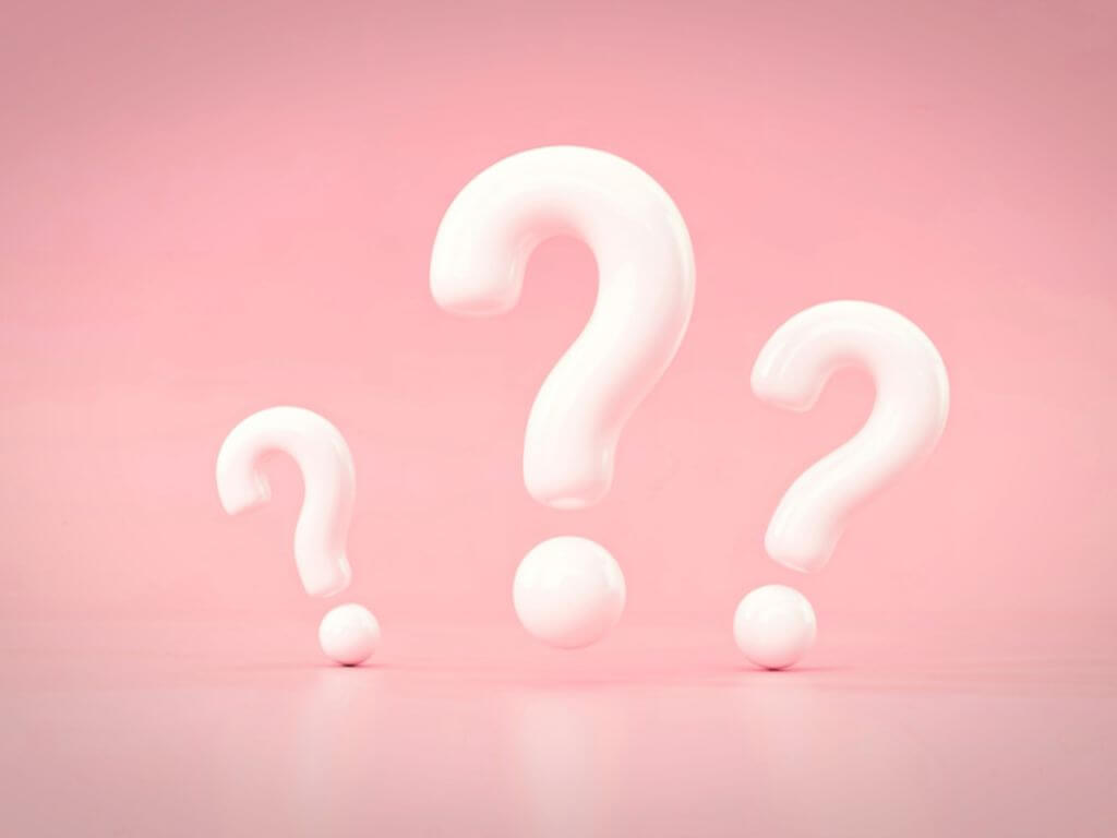 疑問をイメージさせるピンク背景のクエスチョンマーク