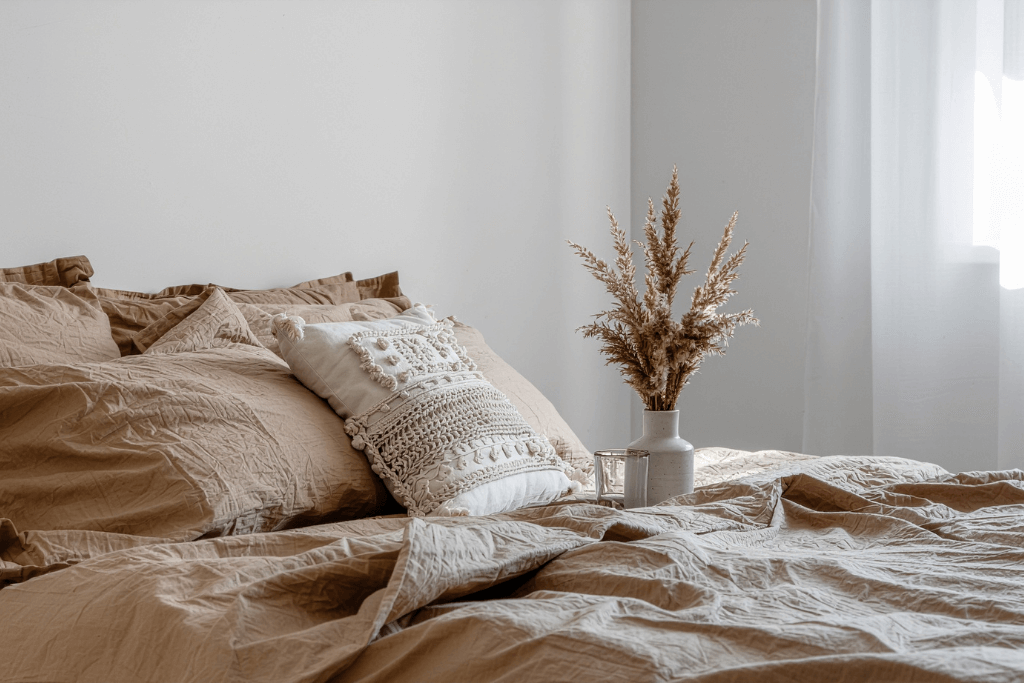 ベージュ系の寝具とクッションを組み合わせたナチュラルなベッドルーム