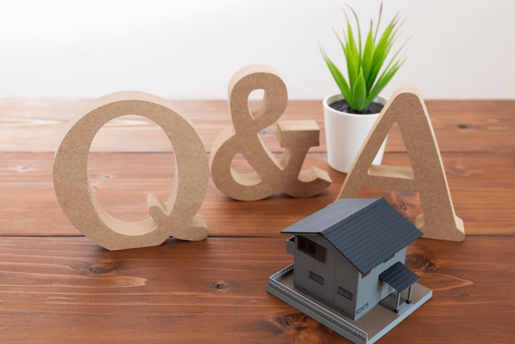 Q&Aの木製オブジェと家の模型が置かれたテーブル