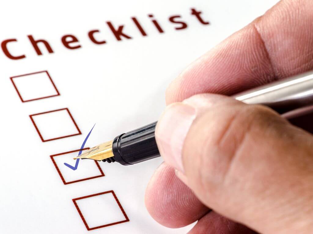 チェックリストにペンでチェックを入れる様子