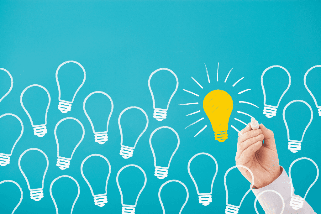 青い背景に描かれた複数の電球と、1つだけ光る黄色の電球