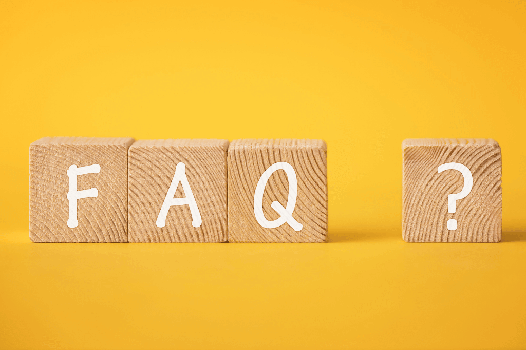 FAQと書かれた木製ブロックとクエスチョンマーク