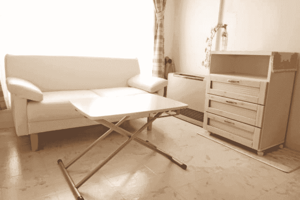 白いソファと昇降式テーブルが置かれた明るいリビング