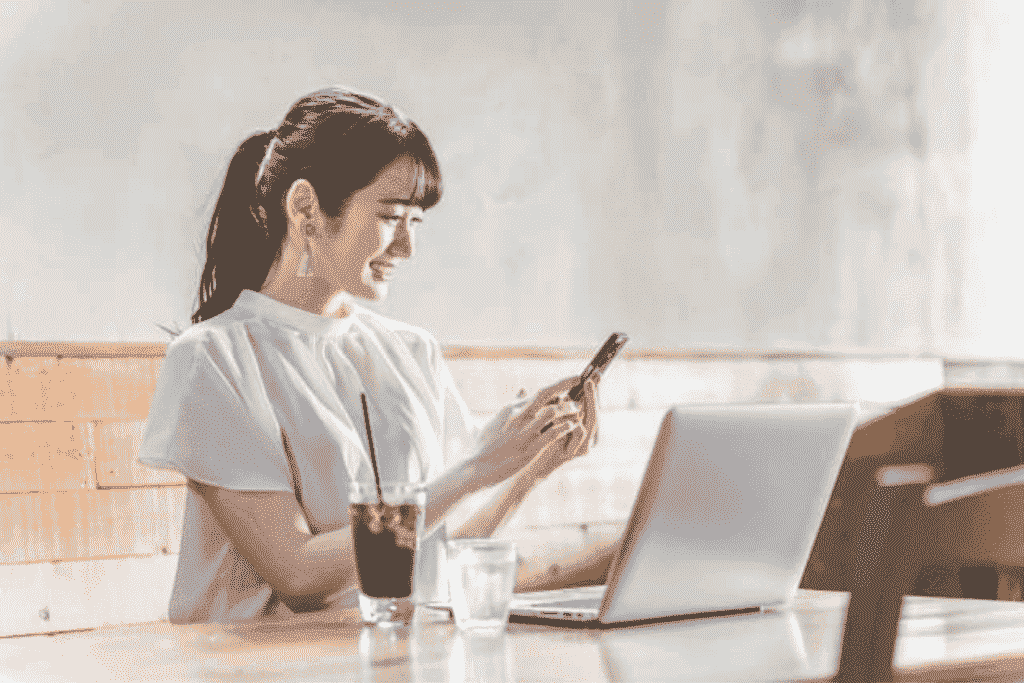 カフェでスマートフォンを操作する女性