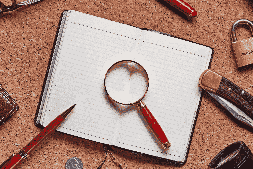 ノートと虫眼鏡で情報を探すイメージ