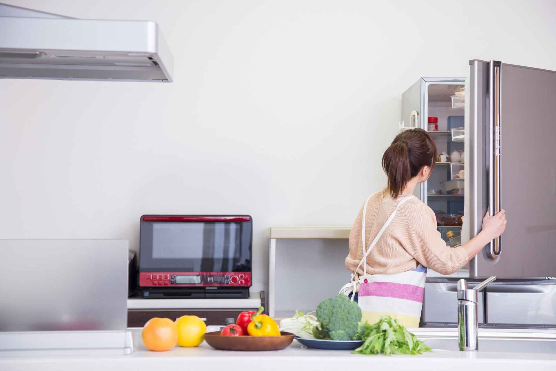 冷蔵庫を見る女性