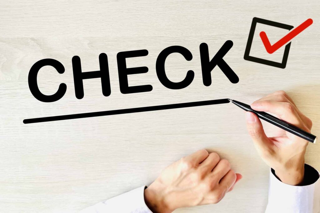 机にチェックの文字を書く手